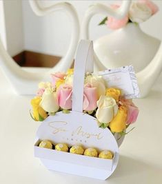 a white box filled with flowers and chocolates