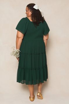 The perfect bridesmaids dress has entered the chat. Introducing our Ellie Dress in Emerald Chiffon! Made from luxurious chiffon fabric, this women's dress features a square neckline with ruffle detailing at the shoulder for a touch of elegance. The 1/2 length flutter sleeves add a playful touch, while the pull-over style with a smocked bodice make it nursing friendly and maternity friendly. The midi-length skirt and full lining add volume and movement to this must-have fall dress. Bridesmaid Tiered Dress With Ruffle Hem, Bridesmaid Midi Dress With Sweetheart Neckline And Ruffles, Flowy Dress With Ruffle Hem And Sweetheart Neckline, Flowy Bridesmaid Dress With Ruffle Hem, Elegant Bridesmaid Midi Dress With Ruffle Hem, Flowy Chiffon Bridesmaid Dress With Pleated Bodice, Ruched Chiffon Dress For Wedding, Chiffon Midi Dress With Ruffles For Wedding, Chiffon Midi Dress With Ruffles For Wedding Guests