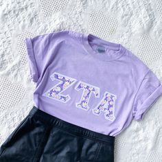 These classic and vintage-style letters are perfect for new and seasoned sorority women alike! Features double-stitched cottage-style purple daisy letters on a stark white background attached to a comfortable unisex lavender tee. This seller is licensed with Affinity Licensing to ensure a verified, quality product. Care Instructions: Machine wash cold, inside out; Tumble dry low; Low iron as needed Sorority Letters Shirt, Sorority Letter Shirt, Spring Lavender Letter Print Top, Purple Pre-shrunk T-shirt For Spring, Spring Sorority Cotton T-shirt, Sorority Cotton T-shirt For Spring, Sorority Style Cotton T-shirt For Spring, Cute Sorority Shirts, Daisy Letters