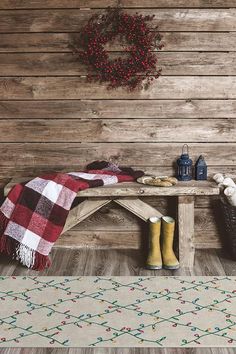 a wooden bench sitting on top of a floor next to a rug