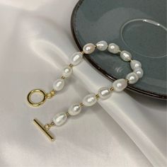 ✨ Genuine White Pearls: Adorn your wrist with the luminous beauty of genuine white pearls, each one carefully selected for its pristine luster and graceful appeal. 🌟 Subtle Gold Accents: The classic design is elevated by subtle gold details, adding a touch of warmth and luxury to this already exquisite piece. 💫 Versatile Simplicity: Designed for everyday elegance, this bracelet seamlessly transitions from casual to formal, making it a versatile accessory for any occasion. 🎁 Timeless Gift: Give the gift of timeless beauty. This bracelet is perfect for commemorating special moments and expressing your enduring affection. ⚖️ Balanced Design: The harmonious balance between the pearls and gold accents creates a bracelet that is both visually striking and elegantly understated. 🌼 Effortless White Pearl Drop Bracelets As Gift, Pearl White Bracelet With Pearl Chain For Gift, Pearl White Bracelet With Pearl Chain As Gift, White Pearl Drop Bracelet For Gift, White Pearl Charm Bracelets For Jewelry Making, Pearl White Pearl Bracelets For Gift, Pearl White Pearl Bracelet As Gift, Pearl White Pearl Bracelet Gift, White Pearl Chain Round Bracelets