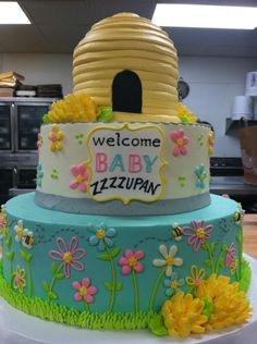 a cake that is decorated with flowers and a beehive