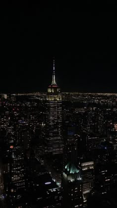 an aerial view of the city at night with lights on and buildings lit up in the dark