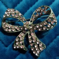 a bow brooch sitting on top of a blue cloth