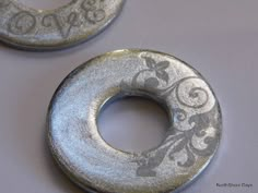 two metal donuts with floral designs on them