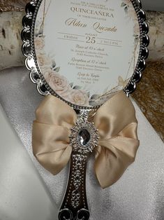 an ornate cross is adorned with a ribbon and jeweled brooch for the baby's first birthday