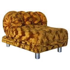 a brown and gold couch sitting on top of a metal leg rest in front of a white background