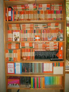 a bookshelf filled with lots of books next to a window