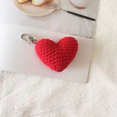 a red crocheted heart keychain sitting on top of a white table