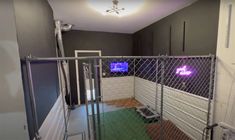 a room with a metal fence and a tv on the wall in it's corner