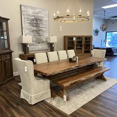 a dining room table with white chairs and a chandelier