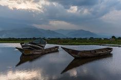 two boats sitting in the middle of a lake