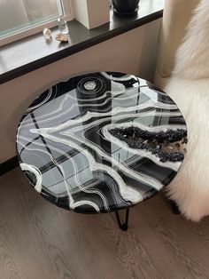 a black and white table sitting on top of a wooden floor