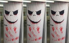 three white banners with red and black paint on them, each decorated as a scary face