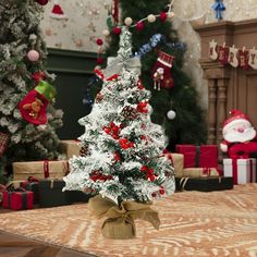 a small christmas tree sitting on top of a wooden table next to other christmas trees