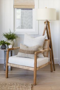 a chair with pillows on it sitting in front of a window