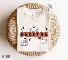 Get ready to join the Spooky Maestra Squad with this Halloween Maestra shirt! Celebrate your Halloween classroom party in style with a playful pumpkin ghost design, perfect for bilingual teachers who love Halloween. ✨ Please check the SIZE CHART image on the listing, and choose your size accordingly before placing your order.  🚫We do not accept exchanges, returns, or cancellations, however, if there are any quality issues with the item please contact us right away. We'll be happy to make things Teacher Halloween Shirts, Halloween Teacher Shirts, Classroom Vibes, Prek Crafts, Classroom Halloween Party, Ghost Tshirt, Teacher Board, Spanish Shirts, Halloween Classroom