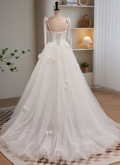 a white wedding dress on display in front of a window