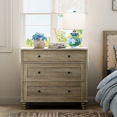 a bedroom scene with focus on the dresser and bed side table in the foreground