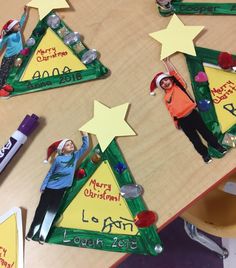 three christmas trees with children's names and stars on them, all made out of construction paper