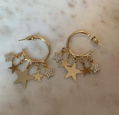 25mm gold filled  hoops with a total of 10 star charms- 5 on each earring. gold filled and the cz starts are gold plated  Do not get wet, do not swim or shower with them on they are gold filled so non tarnish but to preserve the shine and quality Gold Plated Star Hoop Earrings Tarnish Resistant, Gold Plated Star Hoop Earrings, Gold Plated Star Shaped Hoop Earrings, Gold-plated Hoop Earrings With Star Charm, Gold Plated Star-shaped Hoop Earrings, Gold Star Charm Hoop Earrings, Gold Plated Hoop Earrings With Star Charm, 14k Gold Filled Dangle Earrings With Star Charm, Star-shaped Hoop Earrings With Dangling Charms