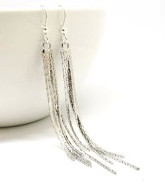 Beautiful bright silver 5 strand snake chain fringe earrings. The ear wires are sterling silver and the snake chain is bright shiny silver plate. The length is 3 1/4 inches from the top of the ear wire. Same earrings in Silver with 3 strands https://etsy.me/2yc46zq Same earrings in Rose Gold with 3 strands https://etsy.me/2sXEjWR Same earrings in Rose Gold with 5 strands https://etsy.me/2HSaBH8 Same earrings in Yellow Gold with 5 strands https://etsy.me/2LPnfZP All items come in a lovely gift bo Silver Earrings Long, Silver Tassel Earrings, Earrings Snake, Long Silver Earrings, Long Chain Earrings, Chain Fringe, Long Tassel Earrings, The Snake, Earrings Long