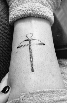 a woman's arm with a tattoo on it that has a hammer and an arrow