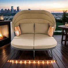 a couch sitting on top of a wooden floor next to a fire place with candles