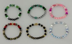 four bracelets with different colored beads and letters on each beaded strand, all in various colors