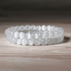 This stone bracelet is a stunning accessory that will brighten up your wrist and your mood. It is handmade with high-quality elastic cord and has a comfortable fit. It measures about 6.7 inches in length and can stretch to fit most wrists. The bracelet is easy to wear and take off, as it has no clasp or closure. This bracelet is perfect for anyone who loves boho chic style, natural stones. It is a unique and meaningful gift for yourself or someone special. You can wear it alone or stack it with White Hand-strung Stretch Bracelet Gift, White Gemstone Beads Bracelet As Gift, White Crystal Bracelet With Natural Stones As Gift, White Crystal Bracelet With Natural Stones For Gift, White Spiritual Stretch Bracelet Gift, Moonstone Beaded Bracelets As Gift, White Crystal Bracelet With Gemstone Beads As Gift, Moonstone Crystal Bracelet With 8mm Beads As Gift, White Round Crystal Bracelet Gift