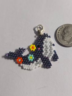 a small beaded keychain is next to a penny