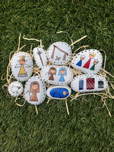 painted rocks with pictures of people on them sitting in the grass next to some straw