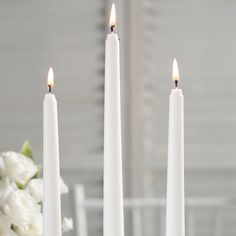 three white candles sitting on top of a table