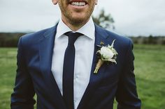 a man in a suit and tie with a boutonniere on his lapel