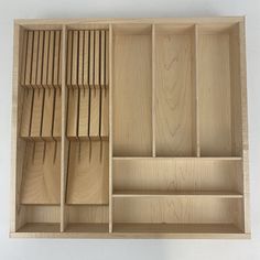 an open wooden drawer with compartments on the inside and sides, all made out of plywood