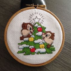 a cross stitch christmas tree with three monkeys