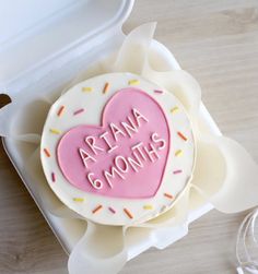 a heart shaped cookie with the words aria and month written in frosting on it