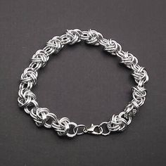 a silver chain bracelet on a black surface