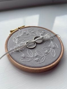 a close up of a embroidery on a table with scissors in the hoop and thread