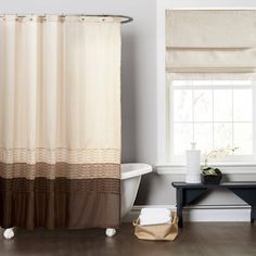 a white bath tub sitting next to a window with a shower curtain in front of it