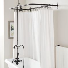 a bath tub sitting next to a white shower curtain