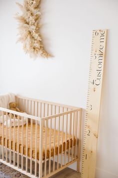 a baby crib next to a tall wooden ruler