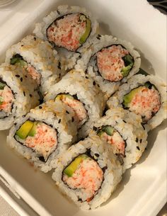 there are many sushi rolls in the white dish on the table and one is cut into eight pieces