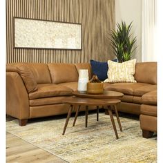 a living room with brown leather couches and a coffee table in front of a striped wall