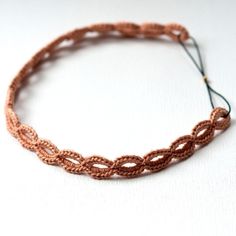 a close up of a bracelet on a white surface with a string attached to it