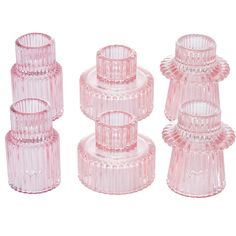 four pink glass candlesticks are stacked on top of each other, one is empty