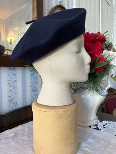 This classic beret is made from wool in dark navy blue. Fits women's size medium (the mannequin's head is 19 1/2 inches around). In very good condition. Classic Wool Beret With Short Brim, Classic Brimmed Wool Beret, Classic Wool Brimmed Beret, Classic Fitted Beret With Short Brim, Classic Fitted Wool Beret, Navy Flat Cap For Winter, Blue Formal Winter Hat, Formal Blue Winter Hat, Elegant Wool Beret Cap