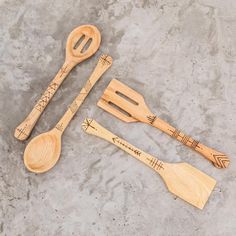 three wooden utensils and two spoons on concrete