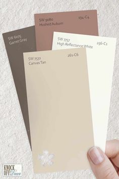 someone holding three different shades of paint in their hand, with the same color swatches