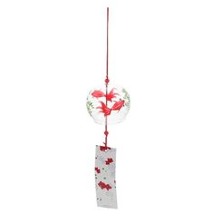 a glass ornament hanging from a red string with two birds on the top